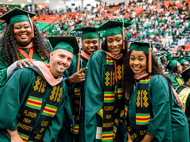 A group of FAMU graduates smiling and posing for a photo at their graduation ceremony.