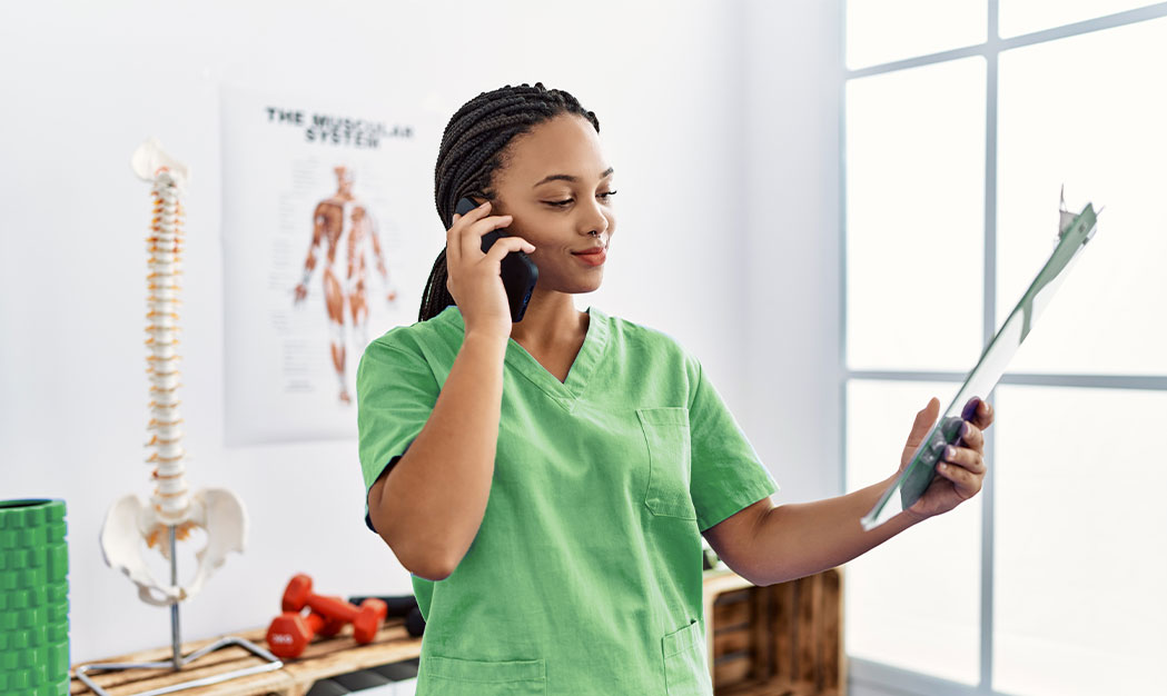 nurse on phone holding clipboard