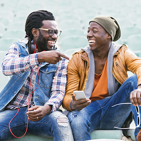 two young adult men smiling and pointing at eachother two young adult men smiling and pointing at eachother