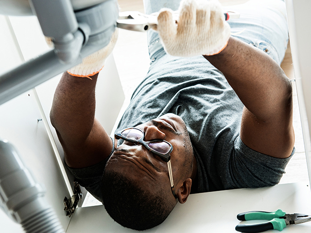 Professional repairman fixing a sink Professional repairman fixing a sink