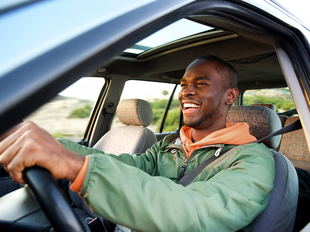Driving and Parking Side portrait of happy african american man driving car
