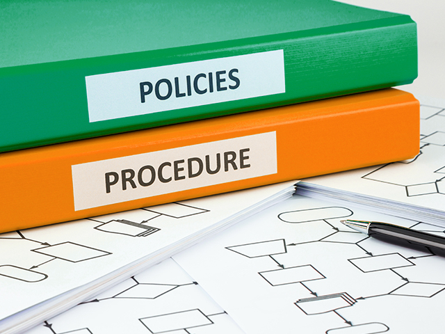Document binders with words "POLICIES" and "PROCEDURE" written on the labels