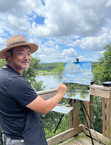 Nan painting at Lake Piney Z over the bridge