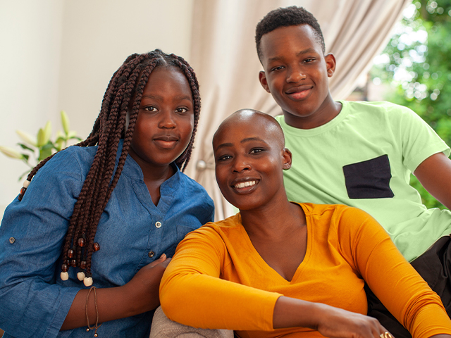 Family of three, mother, daughter, and son, smiling at the camera