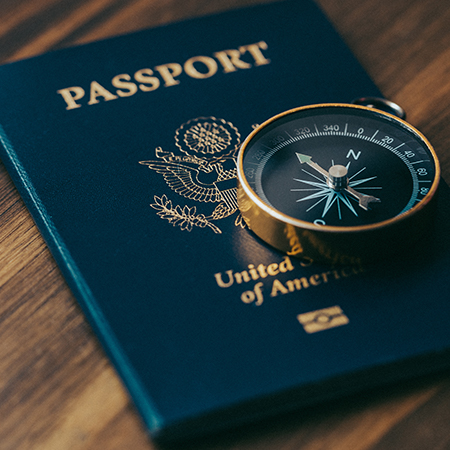 One gold compass on top of a blue American passport