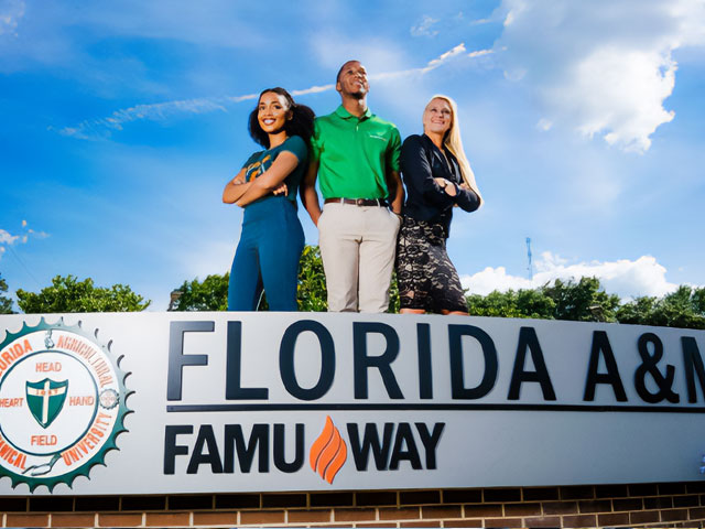 Students standing near FAMU Way sign