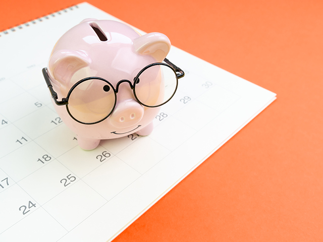 Piggyback wearing glasses sitting on a white calendar on an orange background